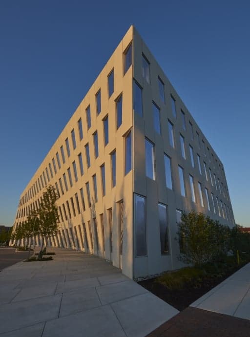 a precast concrete structure with a curved side and lots of windows.