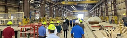 a group of people touring the precast plant